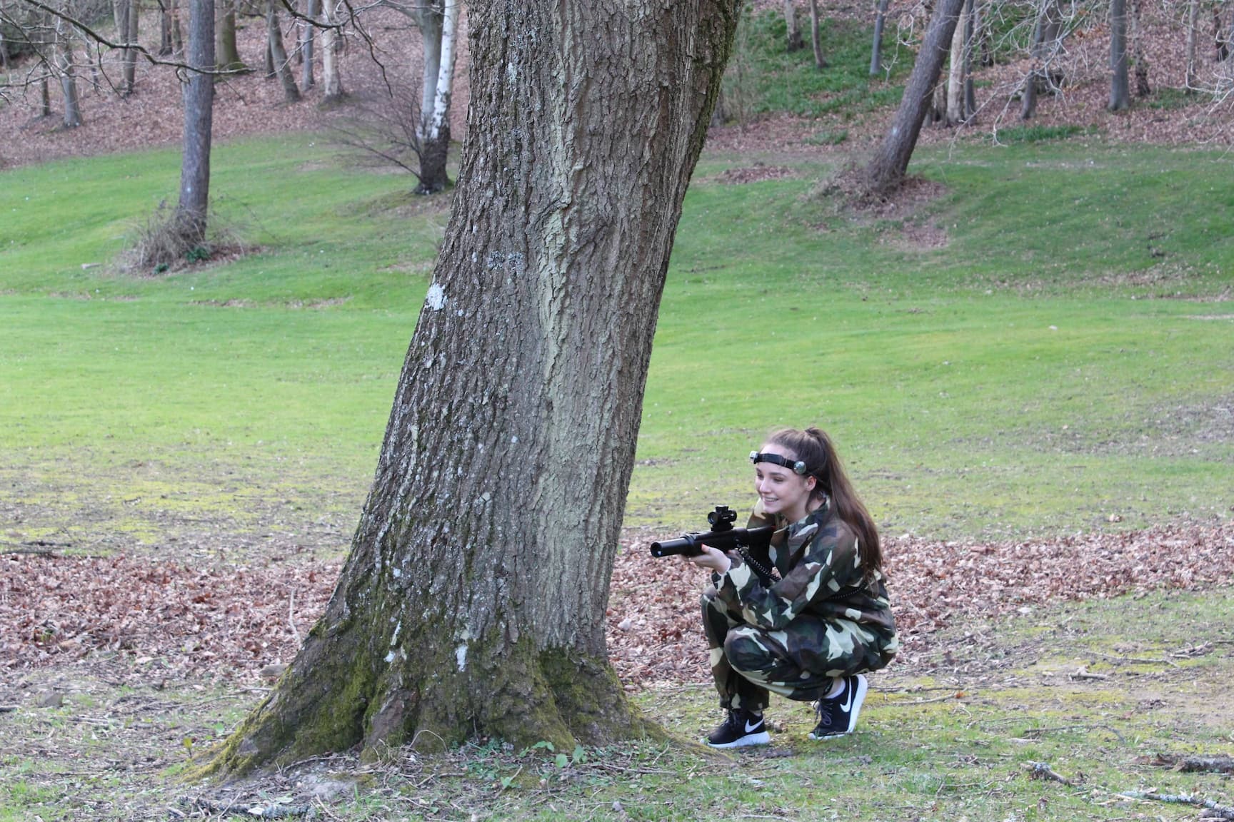 Laser Tag Participant hiding behind a tree