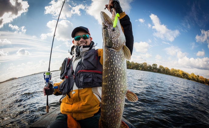 Man holding a pike fish