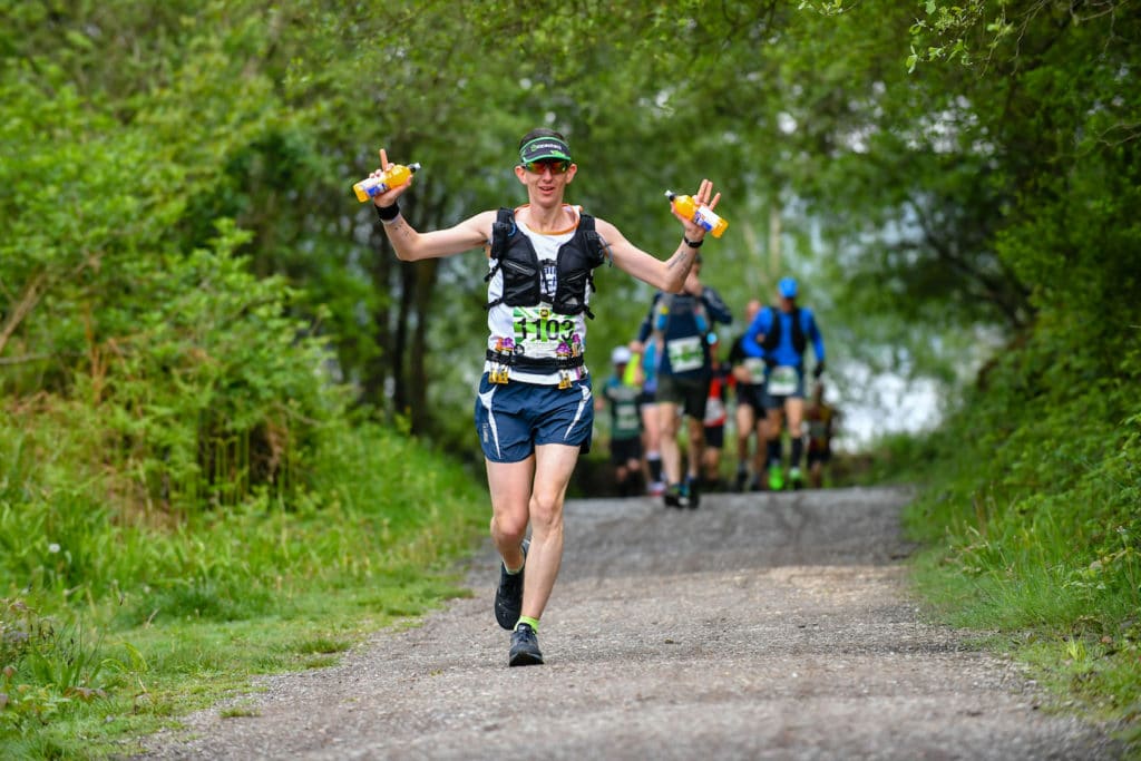 Man Running with his hands up holding bottles of water