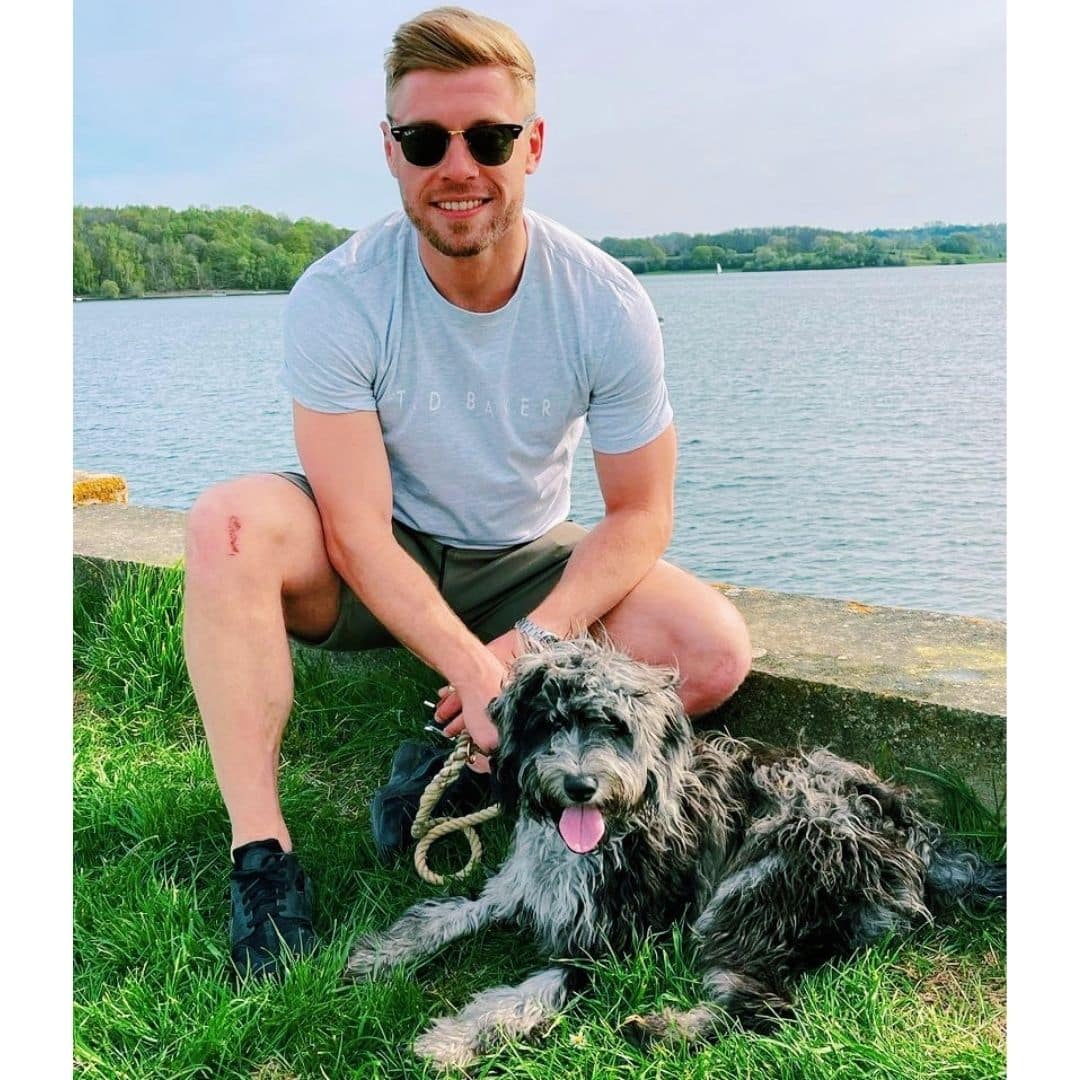 A man posing with his dog.