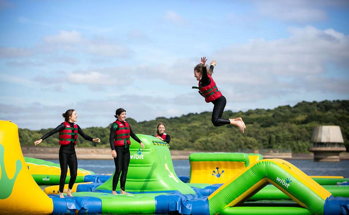 Girls watching another one jump at the wibit inflatables