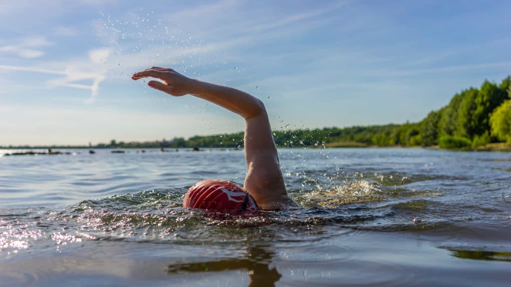 Swimmer with their arm coming out of the water