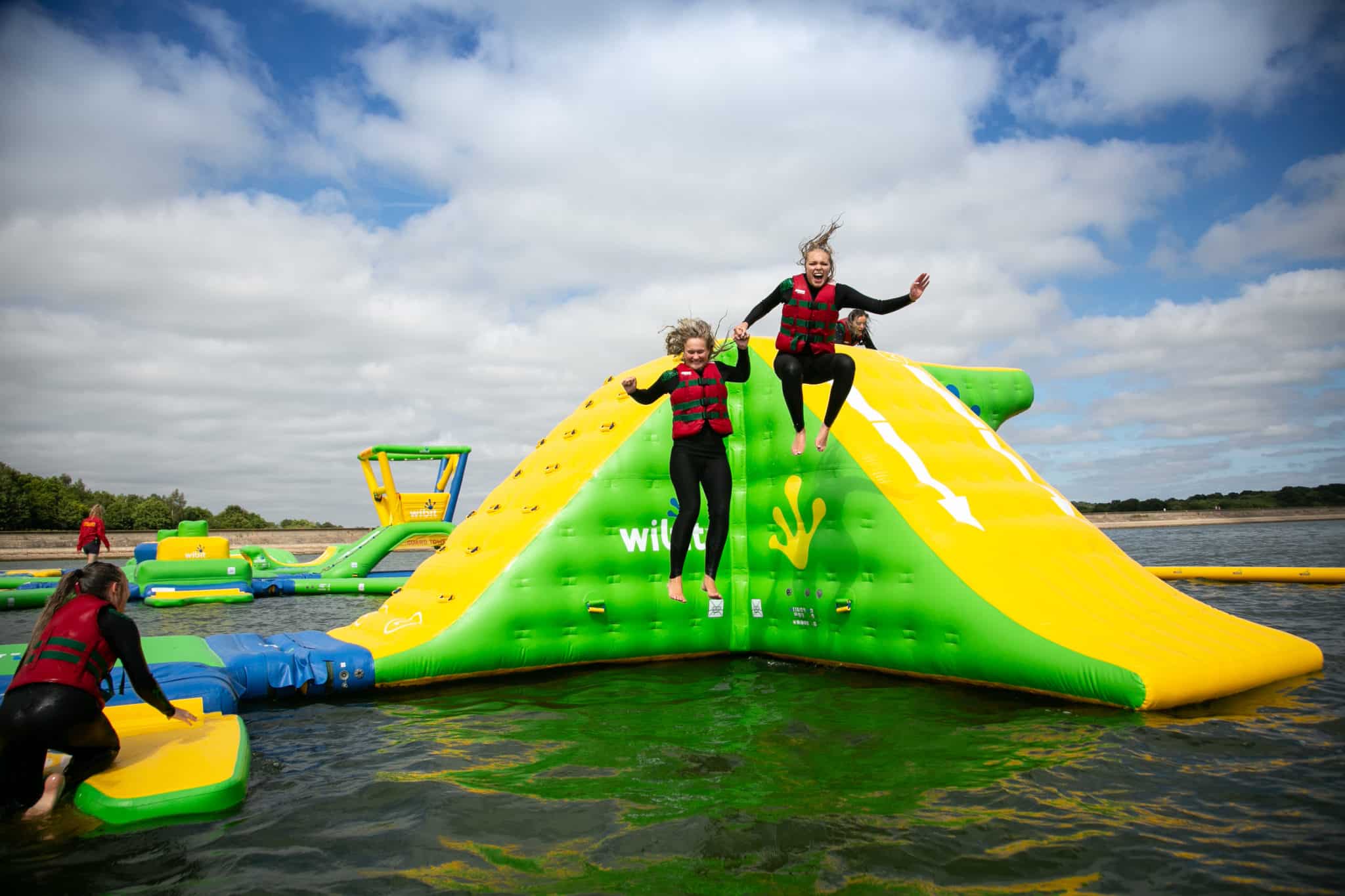 Two people jumping off wibit inflatable at bewl water