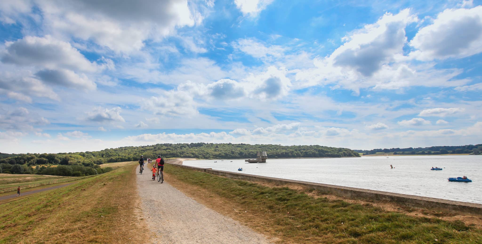 Path next to bewl water reservoir with people cycling and running