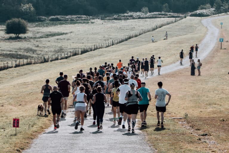 Runners taking part in an autumn marathon running event at Bewl Water in Kent, along the lakeside trail route.