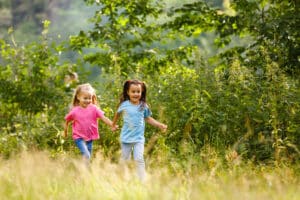 Two little girls running through the grass as they explore the Bewl Water nature trail